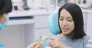 dentist showing the implant tooth to the patient 2021 08 29 05 42 55 utc 1