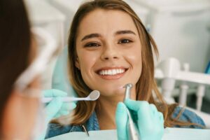 smiling woman sitting in medical chair while denti 2021 09 03 14 07 45 utc 1 e1653633200669